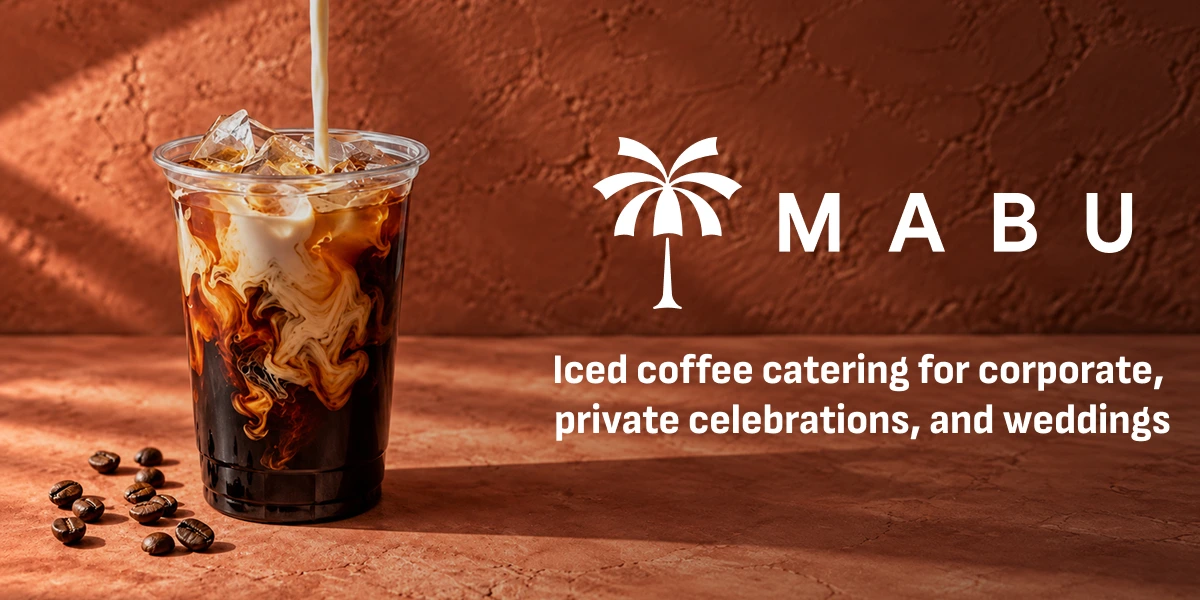 Iced coffee in a clear cup with the Mabu palm tree and umbrella mark